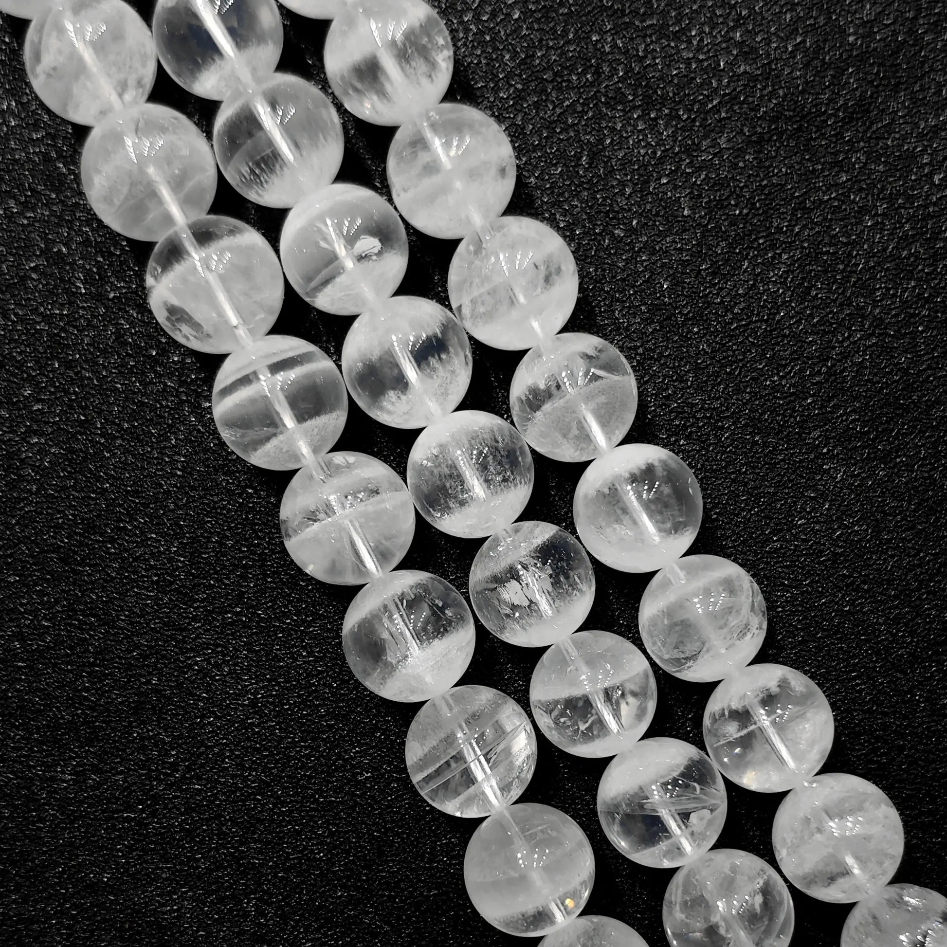 close up of natural white phantom quartz beads showing unique inner ghost formations