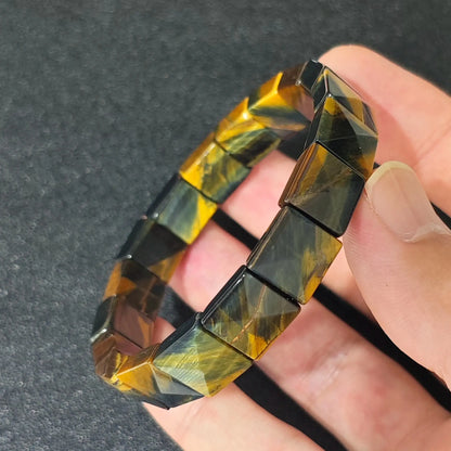 natural yellow blue tigers eye 10x10mm square pyramid bracelet held in hand showing chatoyancy