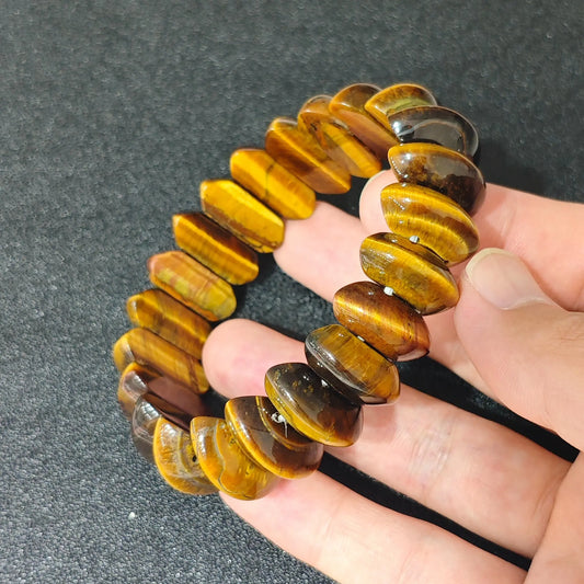 yellow tigers eye crescent moon bead bracelet held in hand highlighting vibrant golden sheen