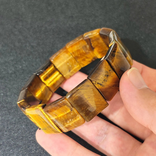 natural yellow tigers eye plate cuff bracelet held in hand showing golden brown rectangular beads