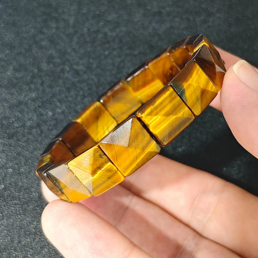 natural yellow tigers eye 11x11mm square pyramid bracelet held in hand showing golden chatoyancy