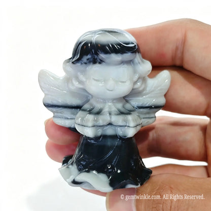 Single natural zebra stone praying angel statue 6cm height held in hand showing black and white stripes
