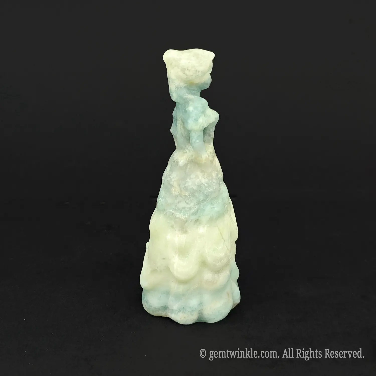 Back view of a natural ocean banded crystal queen statue with beautiful white ribbon lines, ideal for fairycore and whimsical room decor