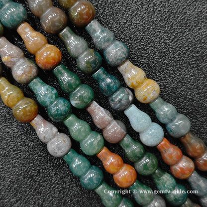 Natural ocean jasper bottle gourd bead strand held over hand for size scale