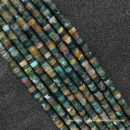 Close up view of 6x3mm ocean jasper disc rondelle beads inspected on fingers for quality preview