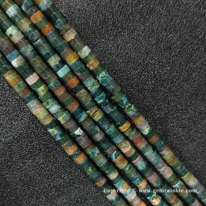 Perspective view of ocean jasper heishi spacer beads showing uniform disc thickness and green hues