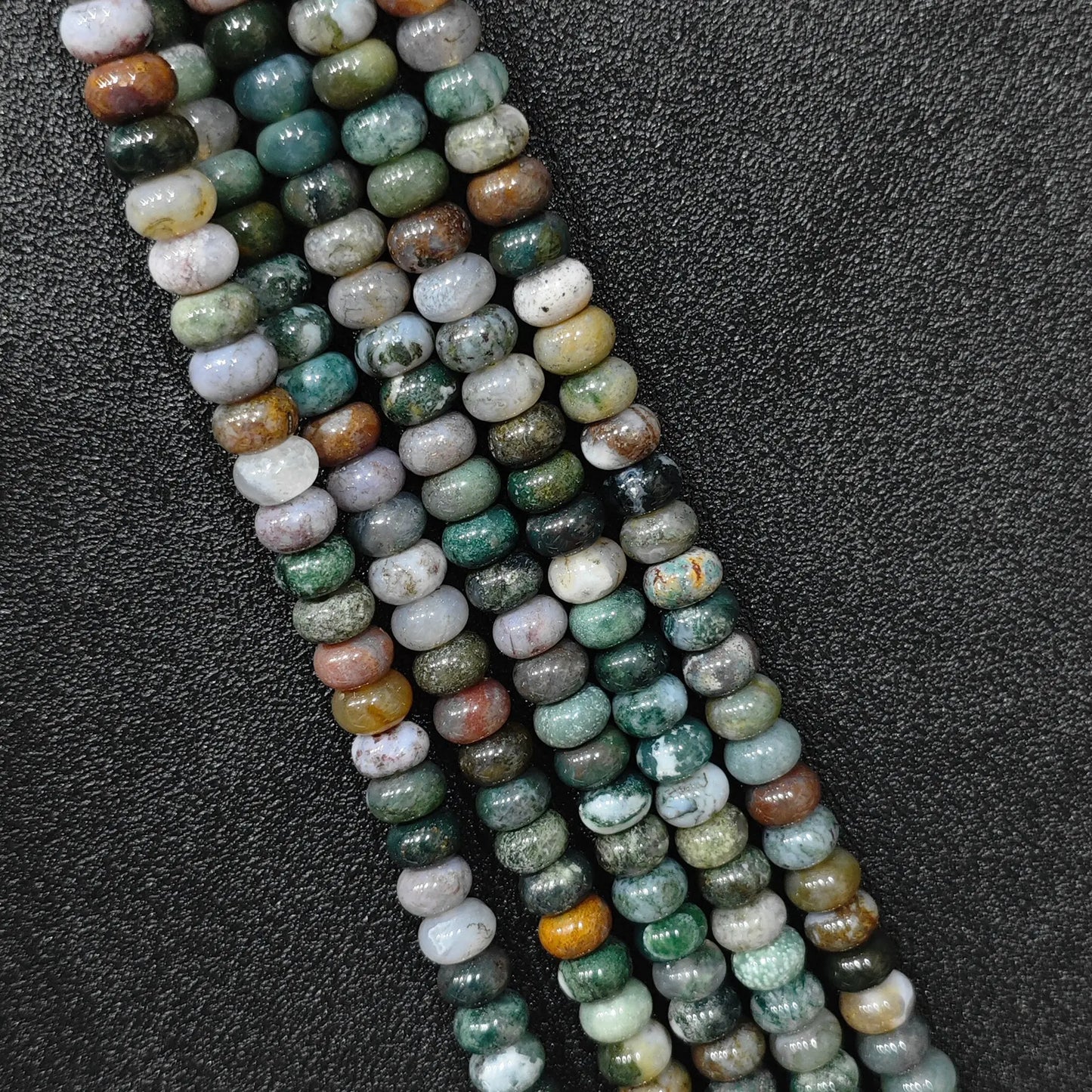 Macro closeup of natural ocean jasper smooth rondelle beads 8x6mm showing multi color orbicular patterns