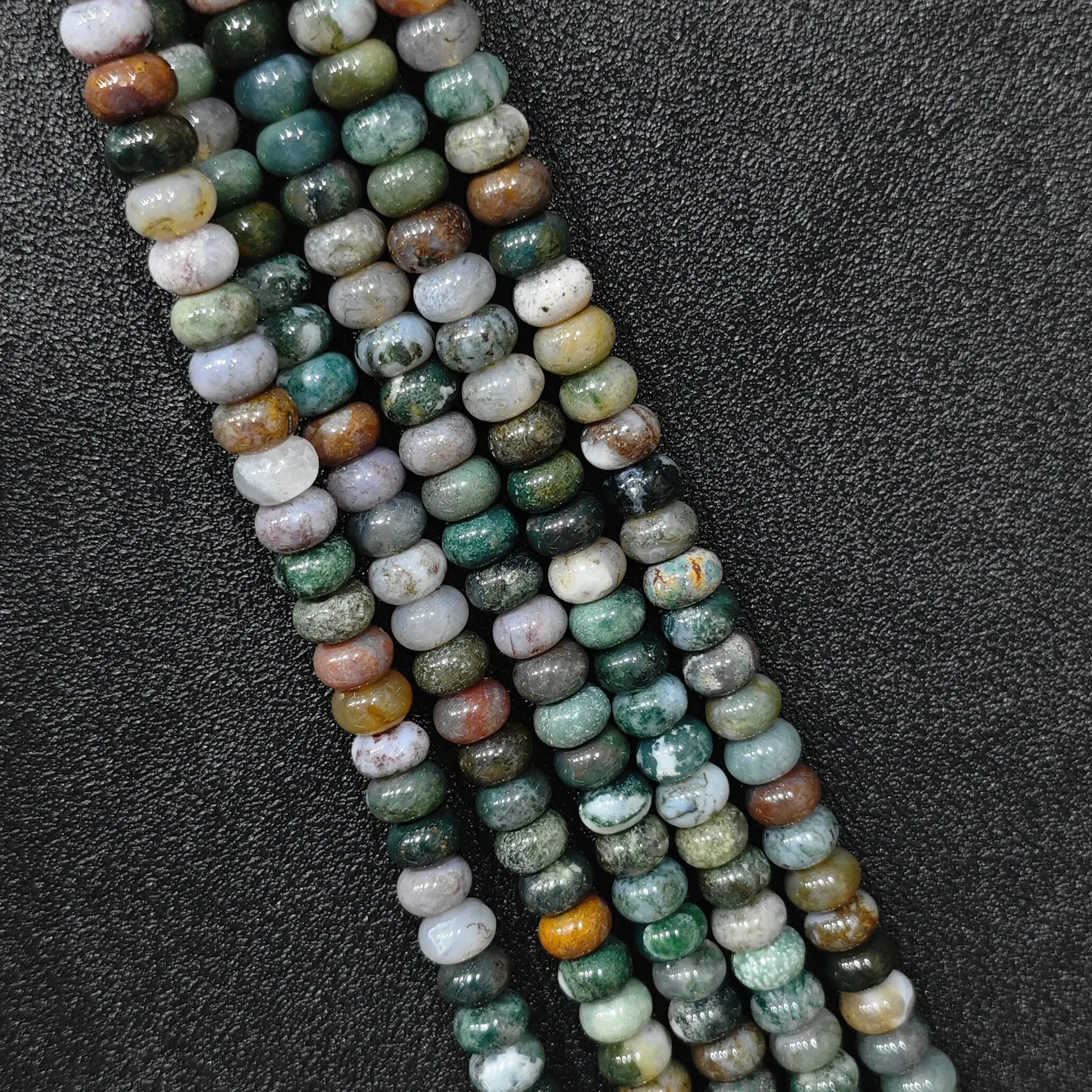Macro closeup of natural ocean jasper smooth rondelle beads 8x6mm showing multi color orbicular patterns