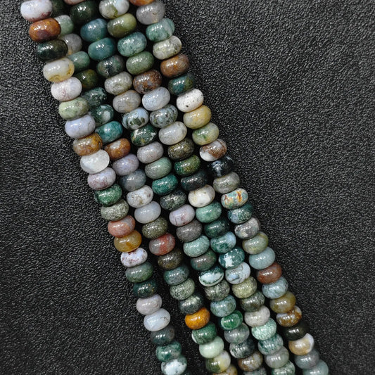 Macro closeup of natural ocean jasper smooth rondelle beads 8x6mm showing multi color orbicular patterns