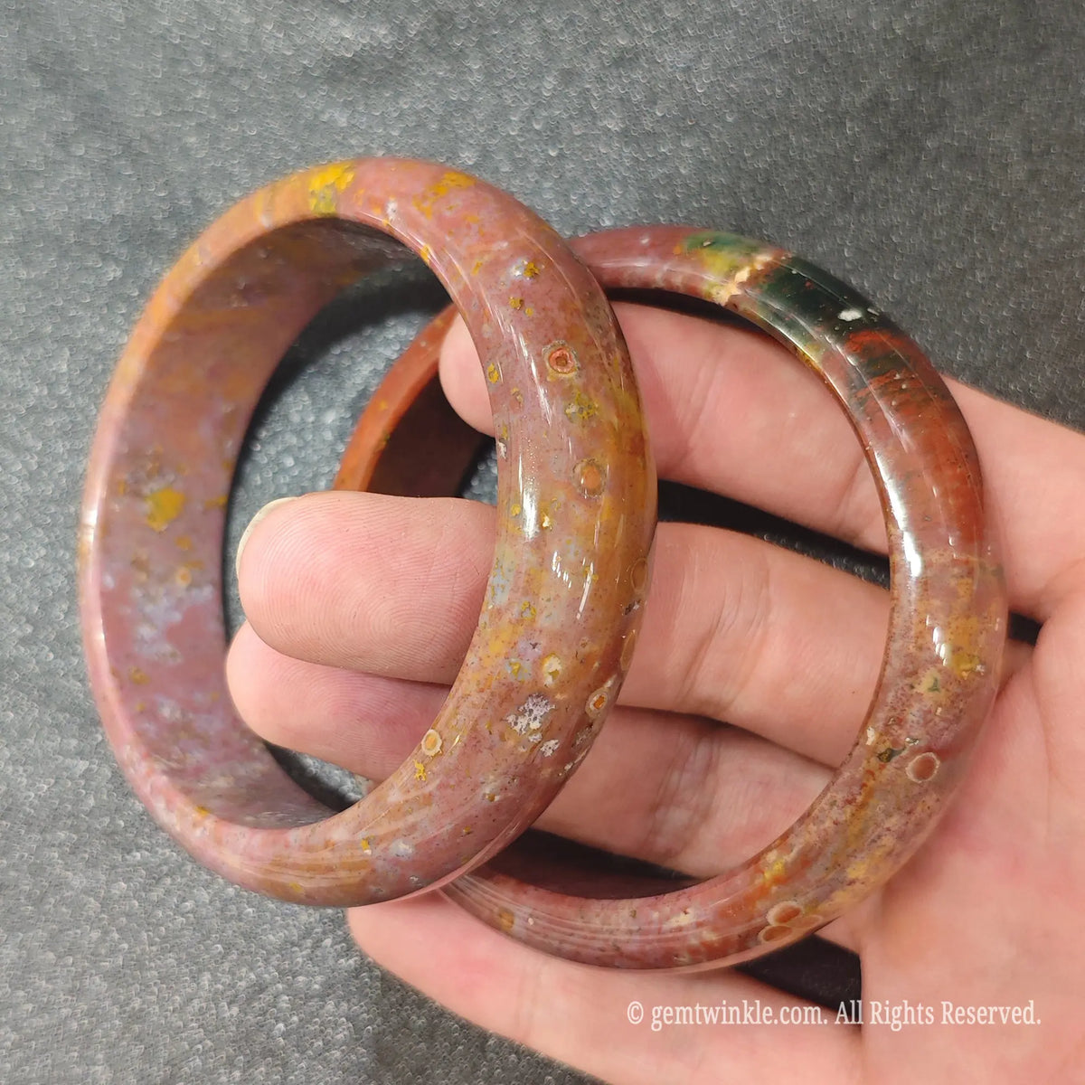 Pair of authentic carved Ocean Jasper bangles showing unique multi-colored mineral patterns