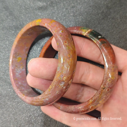 Pair of authentic carved Ocean Jasper bangles showing unique multi-colored mineral patterns