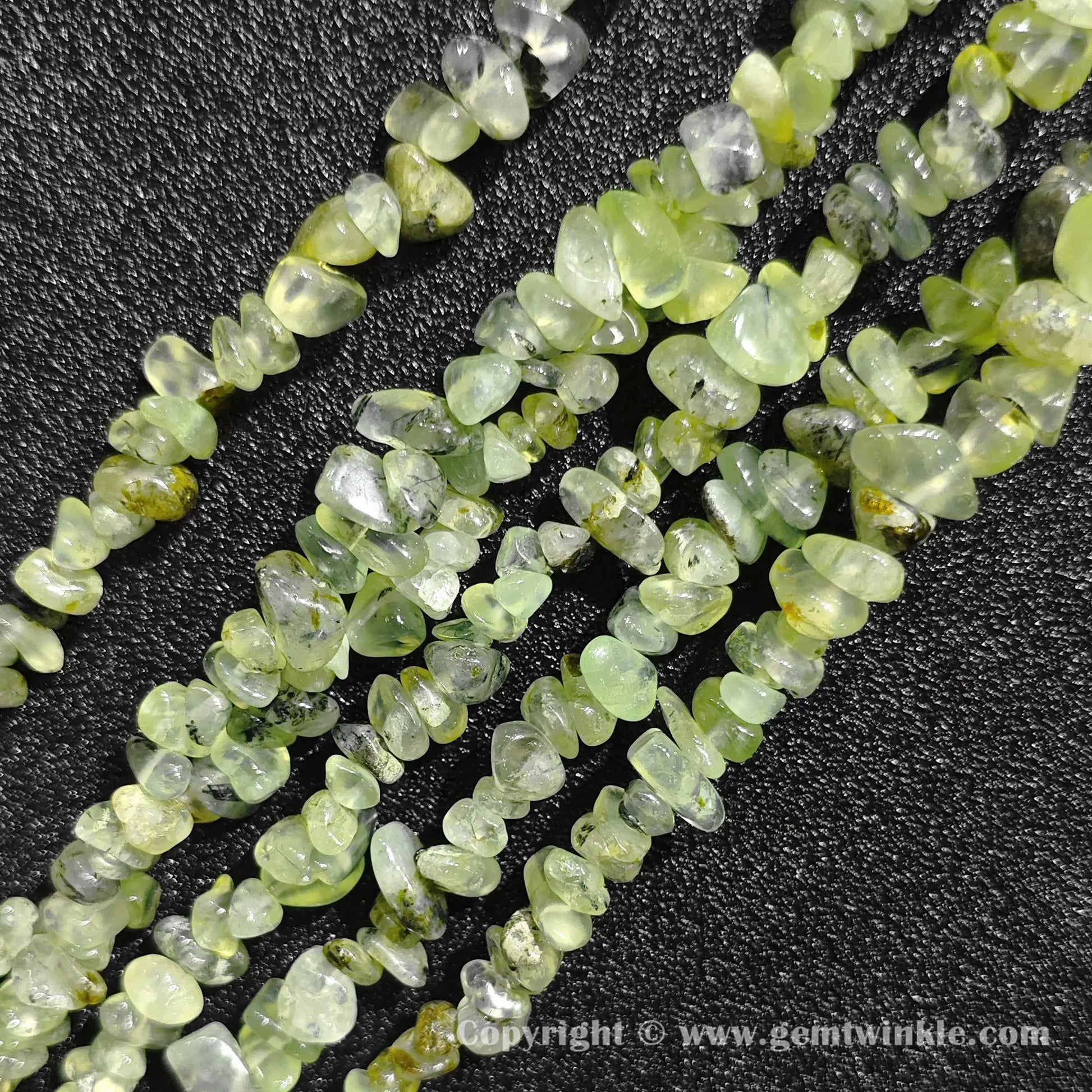 Close up view of tumbled olive green prehnite freeform nugget chip beads