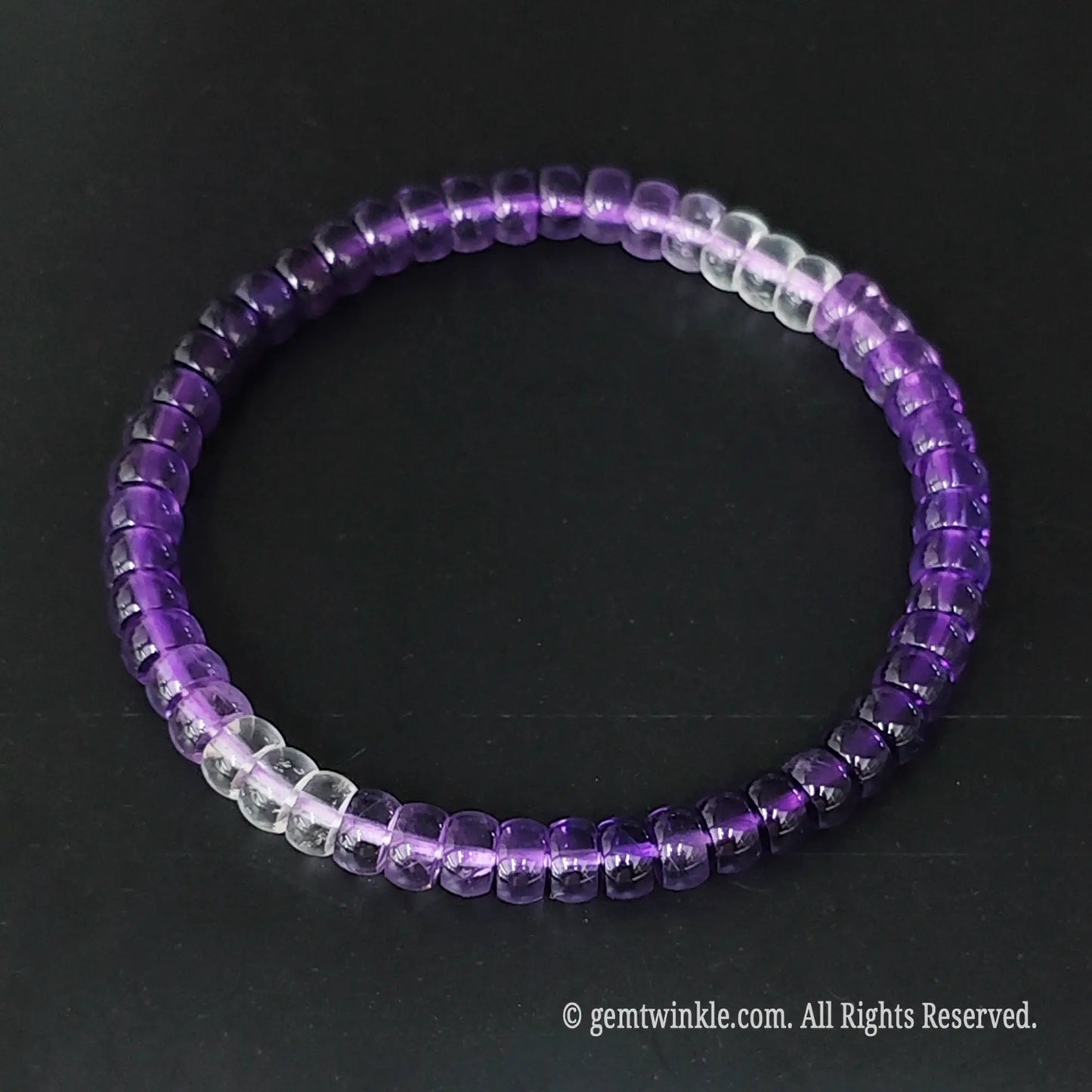 Ombre amethyst small disc bead bracelet held across fingers highlighting smooth wheel bead alignment