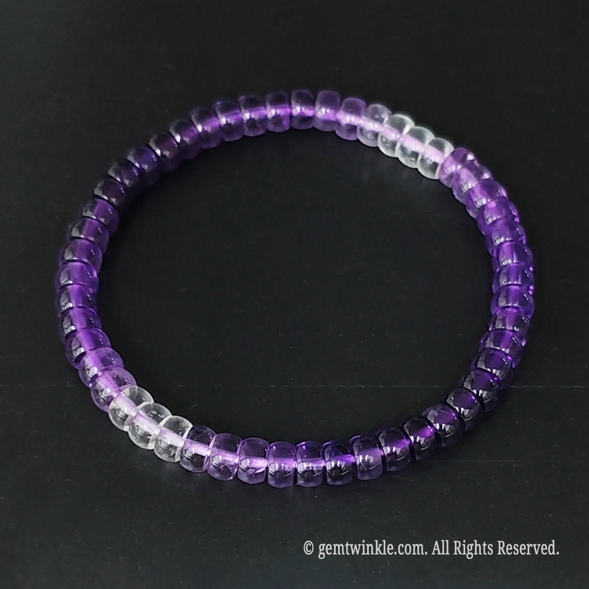 Ombre amethyst small disc bead bracelet held across fingers highlighting smooth wheel bead alignment
