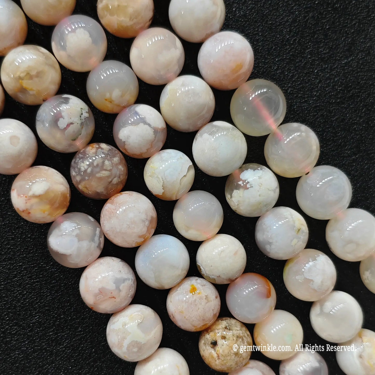 Vertical strands of organic cherry blossom agate beads showcasing translucent quartz matrices and unique internal patterns