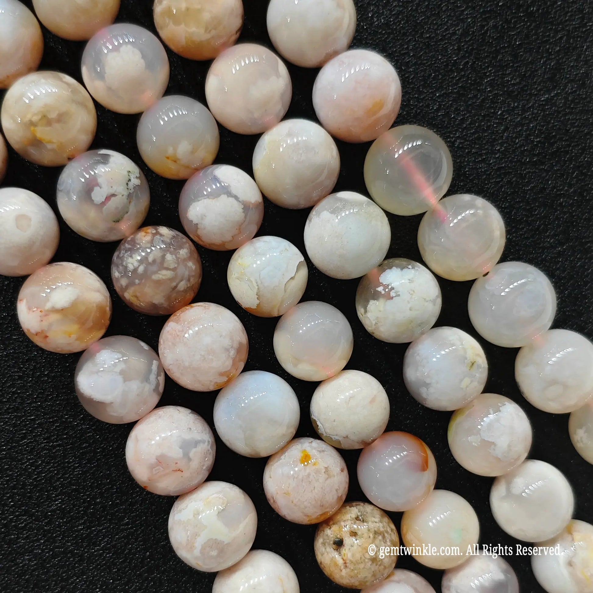 Vertical strands of organic cherry blossom agate beads showcasing translucent quartz matrices and unique internal patterns