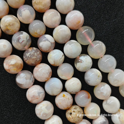 Vertical strands of organic cherry blossom agate beads showcasing translucent quartz matrices and unique internal patterns
