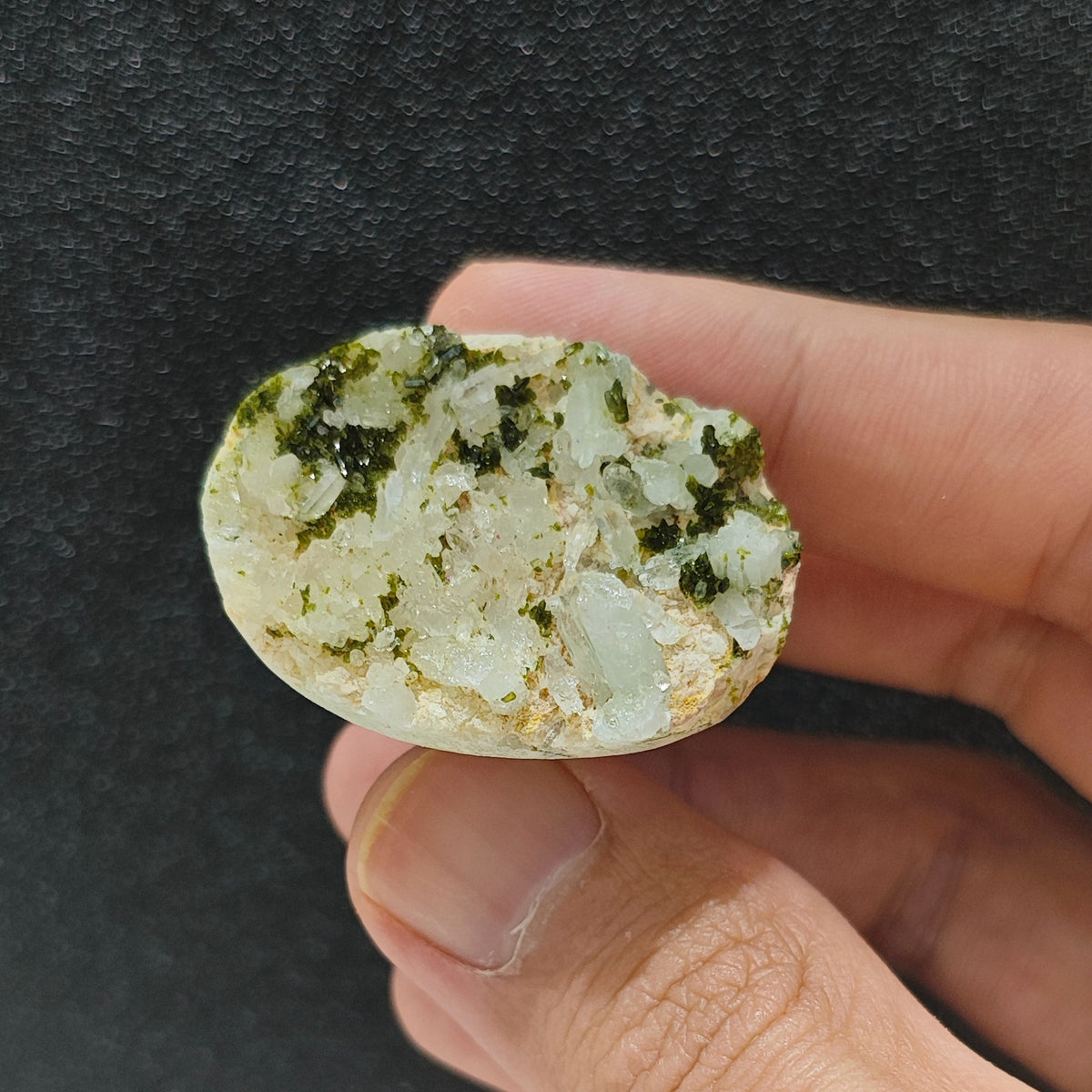 Full view of organic green epidote mineral cluster ring resting in hand displaying unique raw geode texture