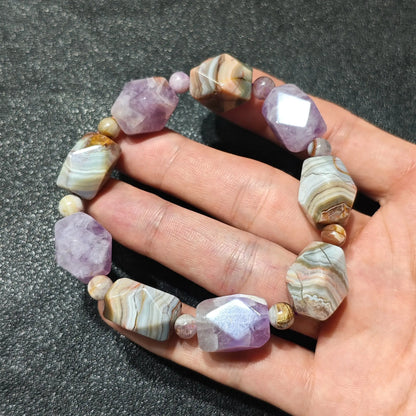 Natural amethyst and banded agate faceted stretch bracelet held on hand displaying purple crystal and striped agate nuggets