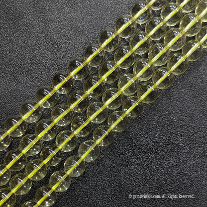Close up of A grade pale yellow citrine crystal round strands with superior high polish and minimal inclusions