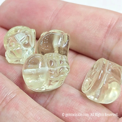 Group preview of carved lemon quartz Pixiu beads in hand highlighting high transparency and smooth polish