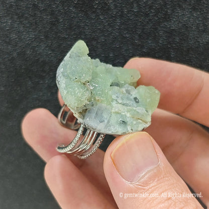 Pale green fluorite crystal specimen ring side view held in hand showing organic raw stone cluster texture