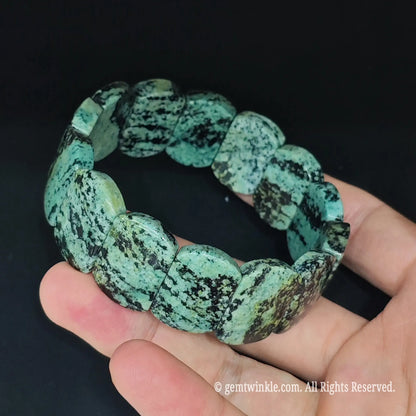 Peacock jasper smooth slab stretch bracelet held open in hand displaying full inner circumference and dual cord structure