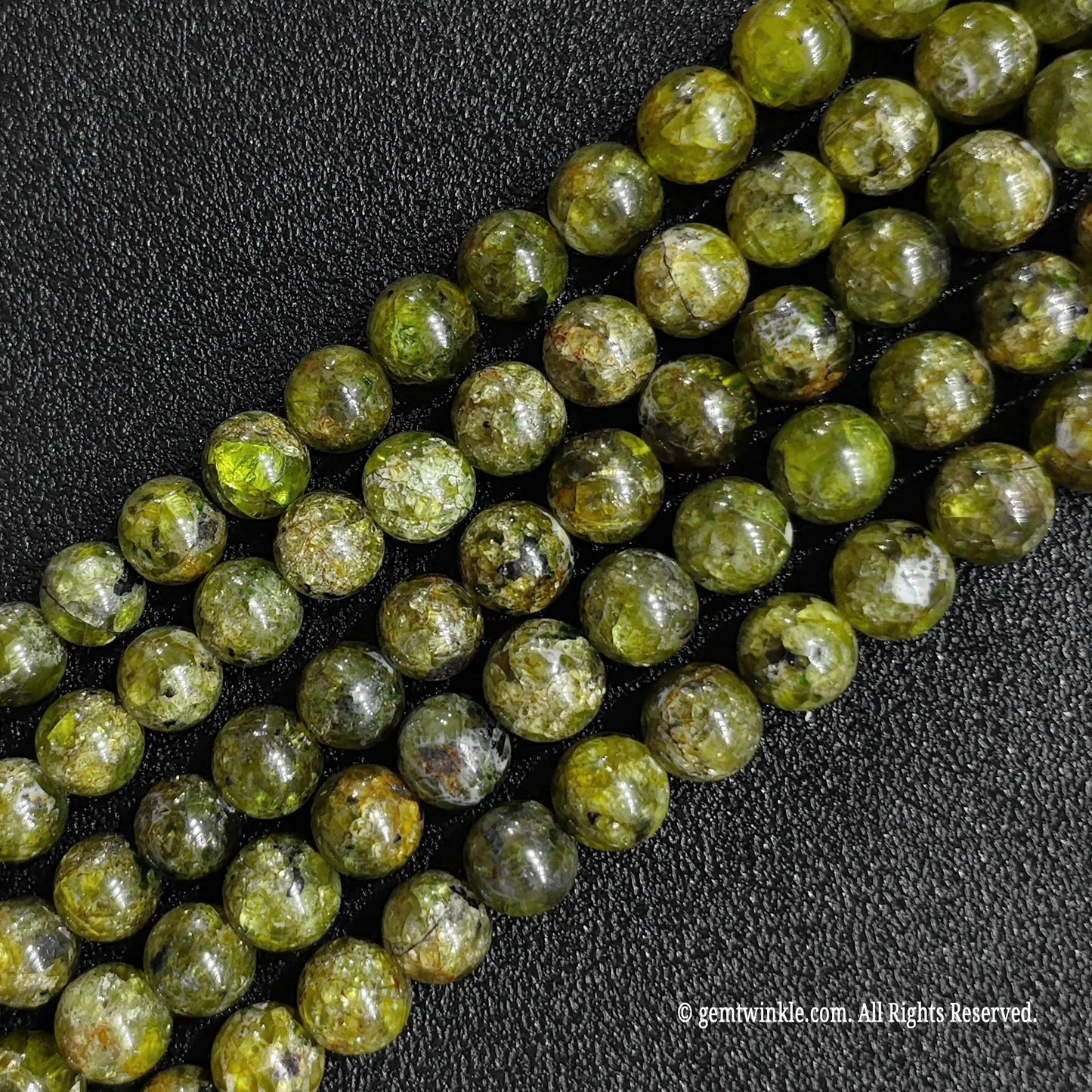 hand holding vertical strands of peridot gemstone beads for size and scale reference
