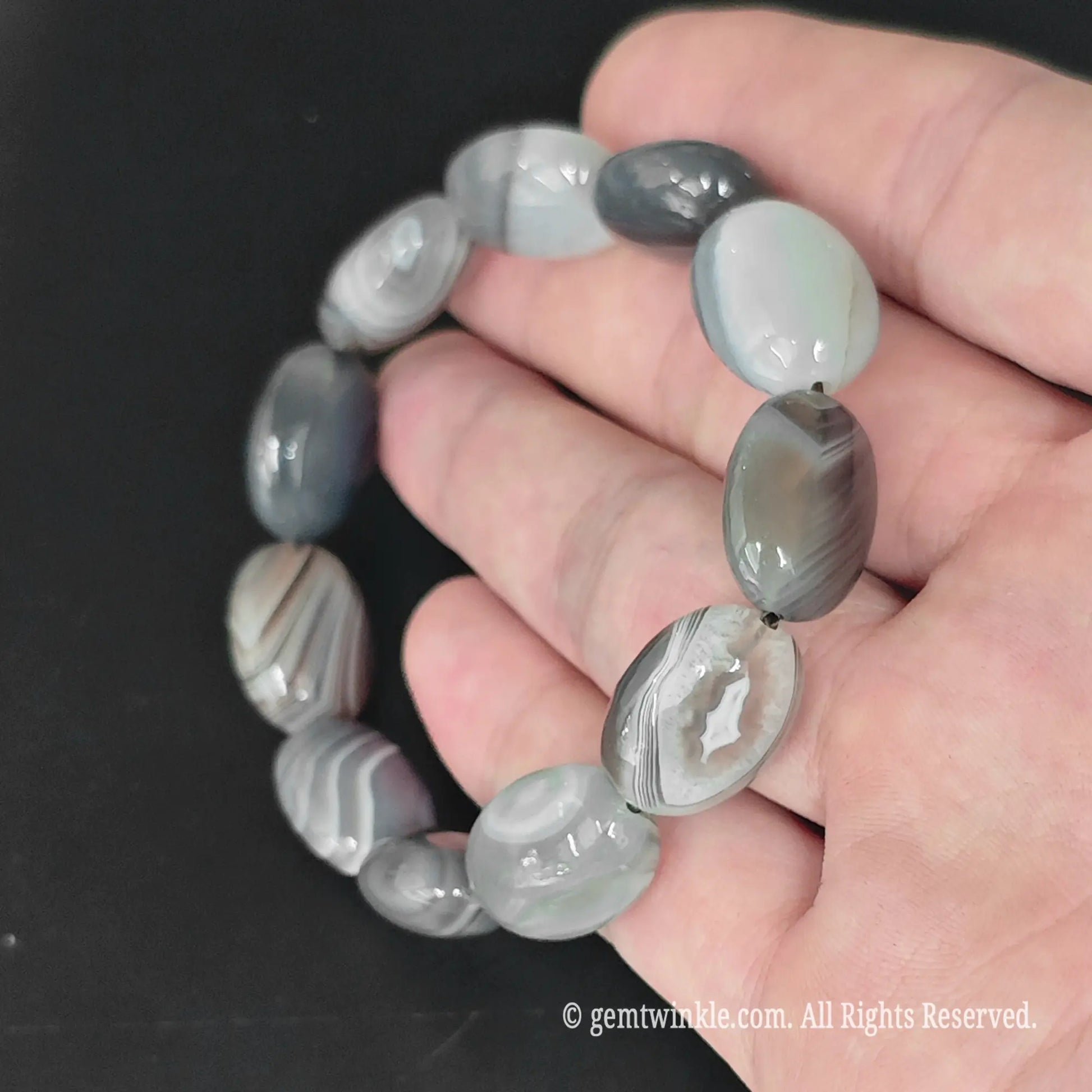 13-15mm grey banded persian agate oval bead stretch bracelet displayed in open hand