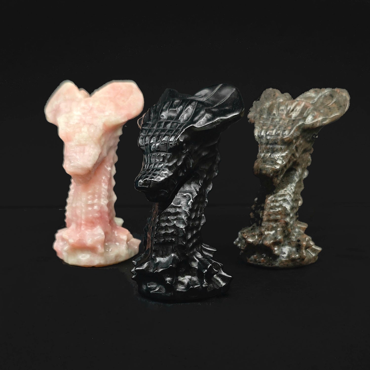 Assorted 7cm hand carved stone dragon head statues in pink opal, black obsidian, and grey spotted stone for fantasy wholesale