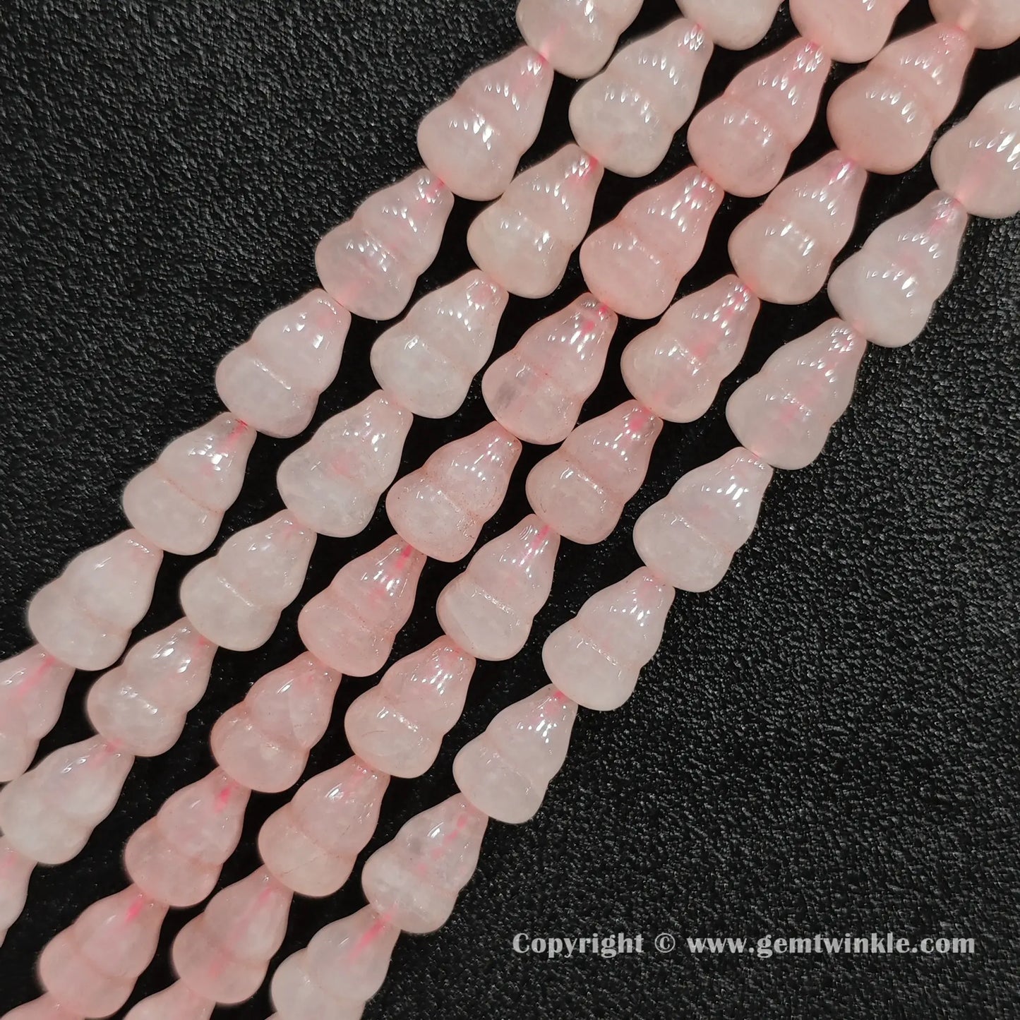 Angled view of natural pastel pink rose quartz calabash cut gemstone strands