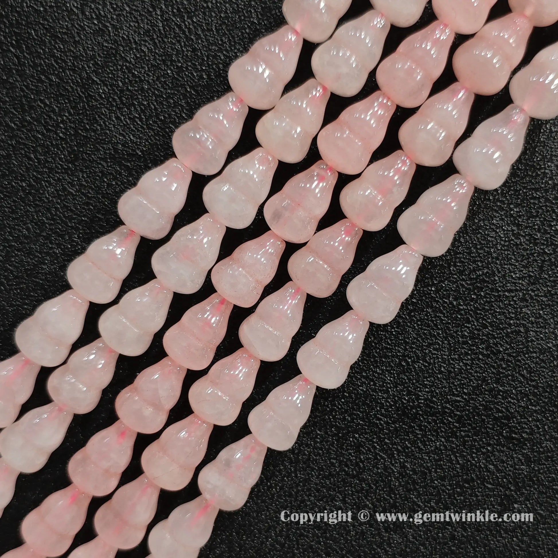 Angled view of natural pastel pink rose quartz calabash cut gemstone strands