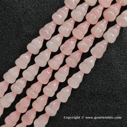 Angled view of natural pastel pink rose quartz calabash cut gemstone strands