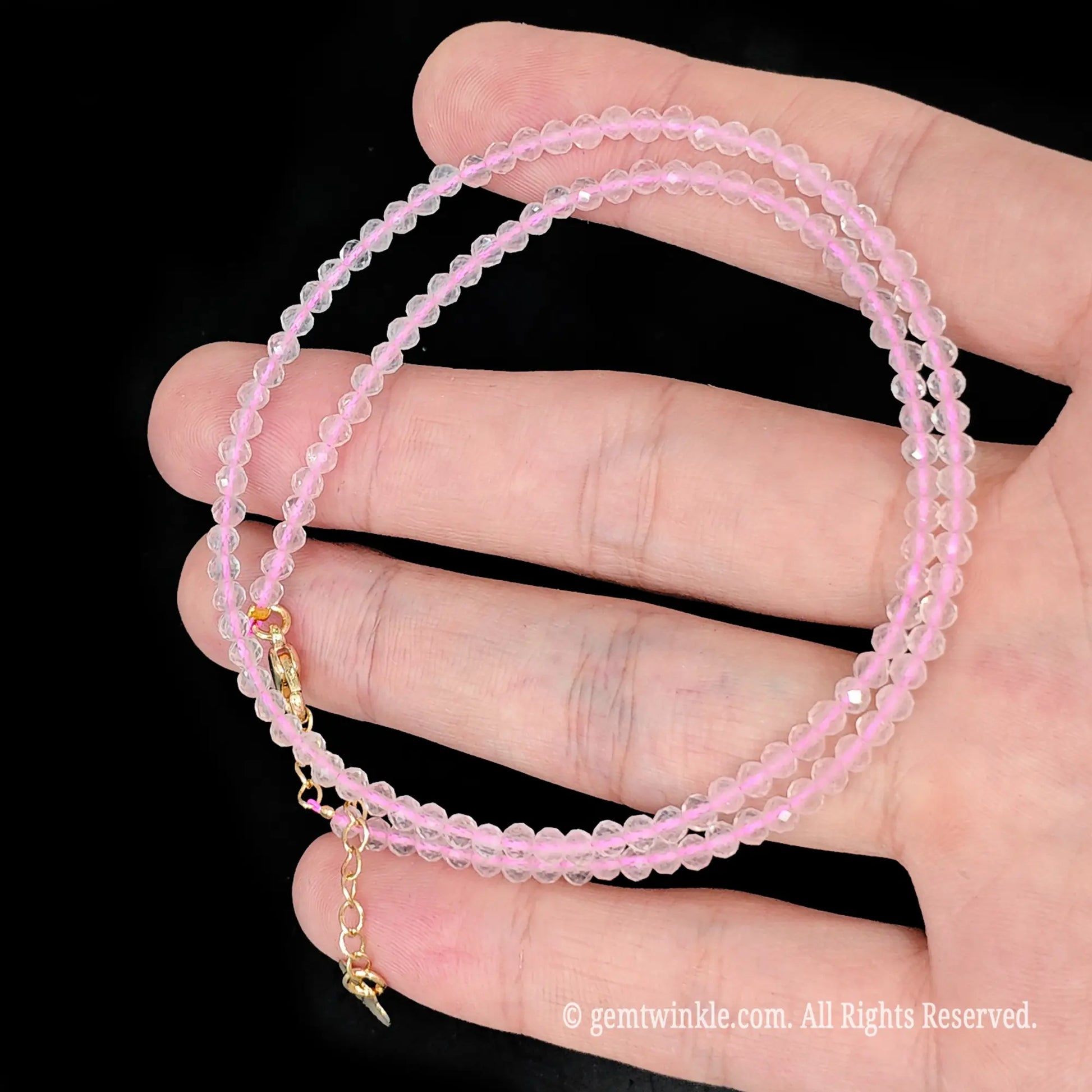 faceted rose quartz micro bead necklace loop with gold tone extender chain in hand
