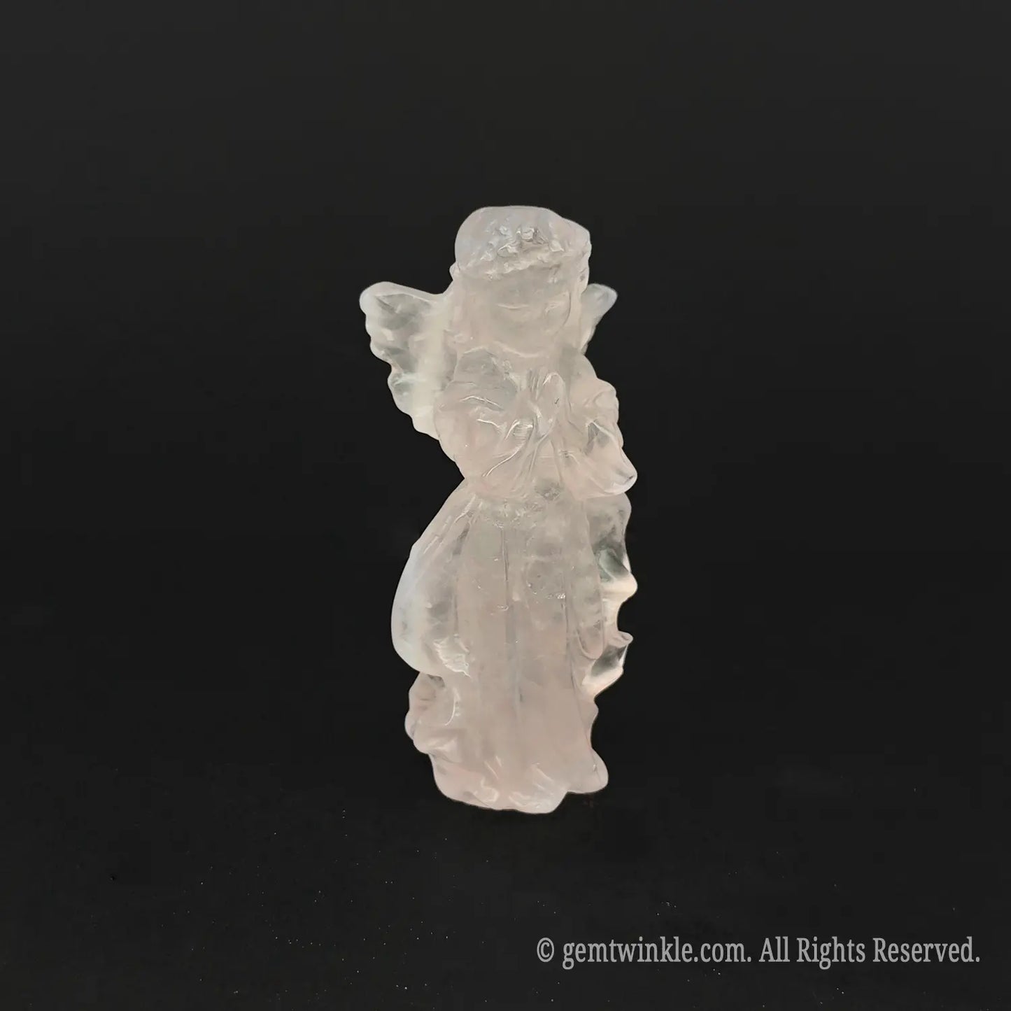 Side view of a hand-carved natural pink rose quartz angel figurine showing detailed wings, flowing drapes, and rich pastel pink colors