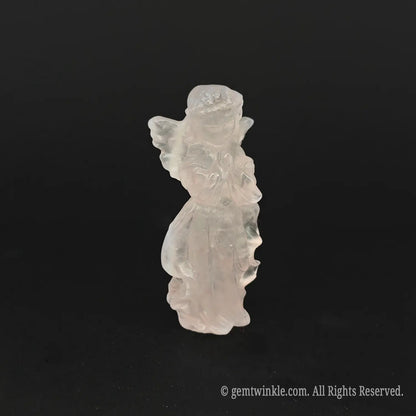 Side view of a hand-carved natural pink rose quartz angel figurine showing detailed wings, flowing drapes, and rich pastel pink colors
