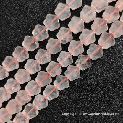 Angled view of natural pastel pink rose quartz star carved gemstone strands