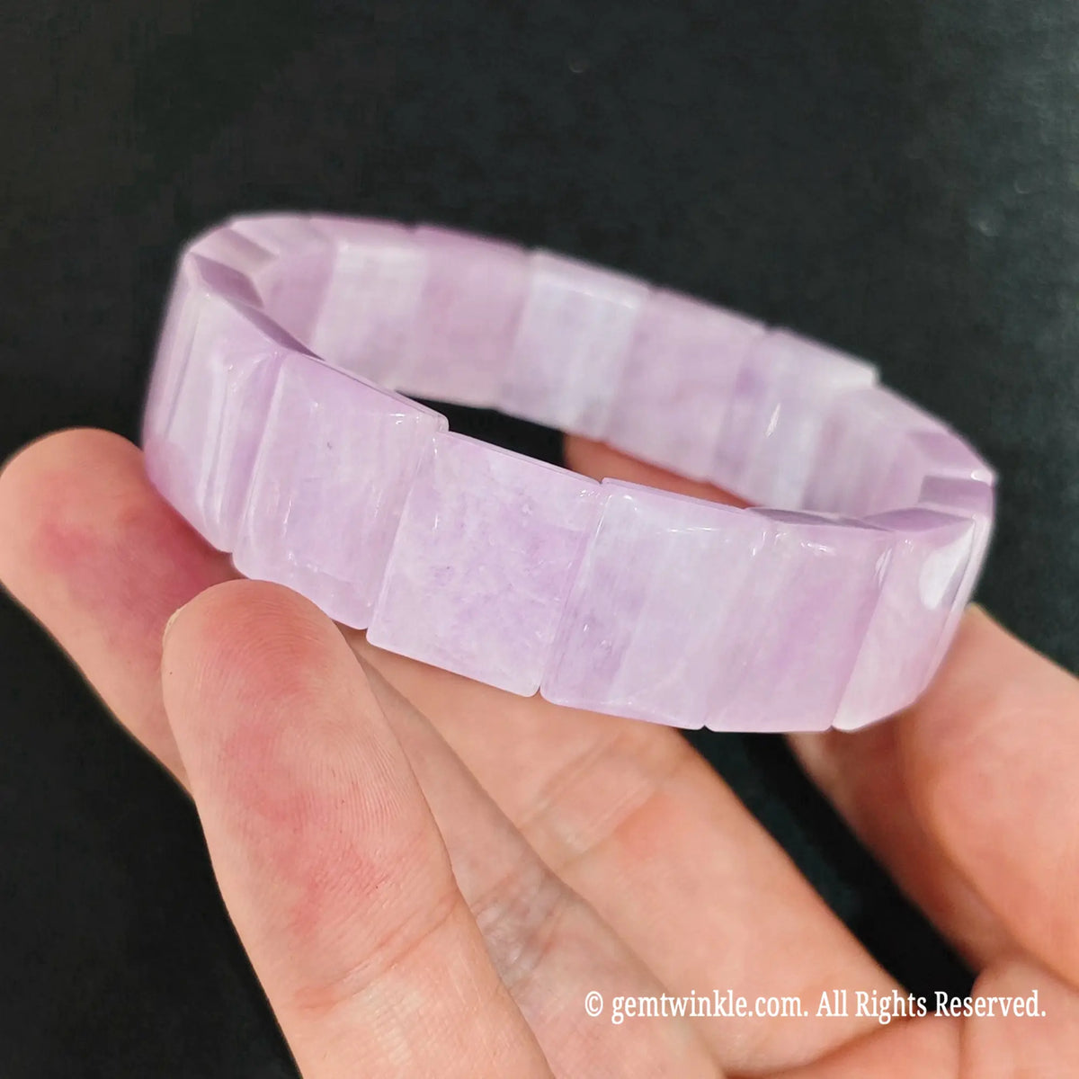 side angle of natural pink kunzite rectangular block elastic bangle on hand showing glossy finish