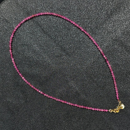 Hand holding 3mm faceted pink tourmaline necklace showing vibrant magenta tones for boutique resellers