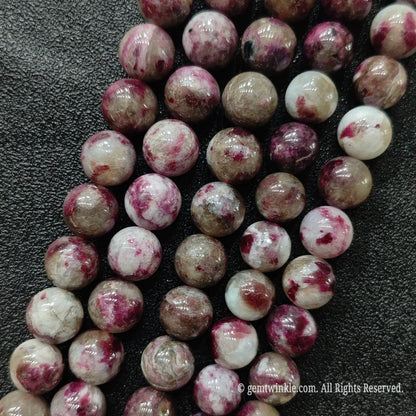 Plum blossom tourmaline round beads strand section showing smooth polished surface and clean drill holes