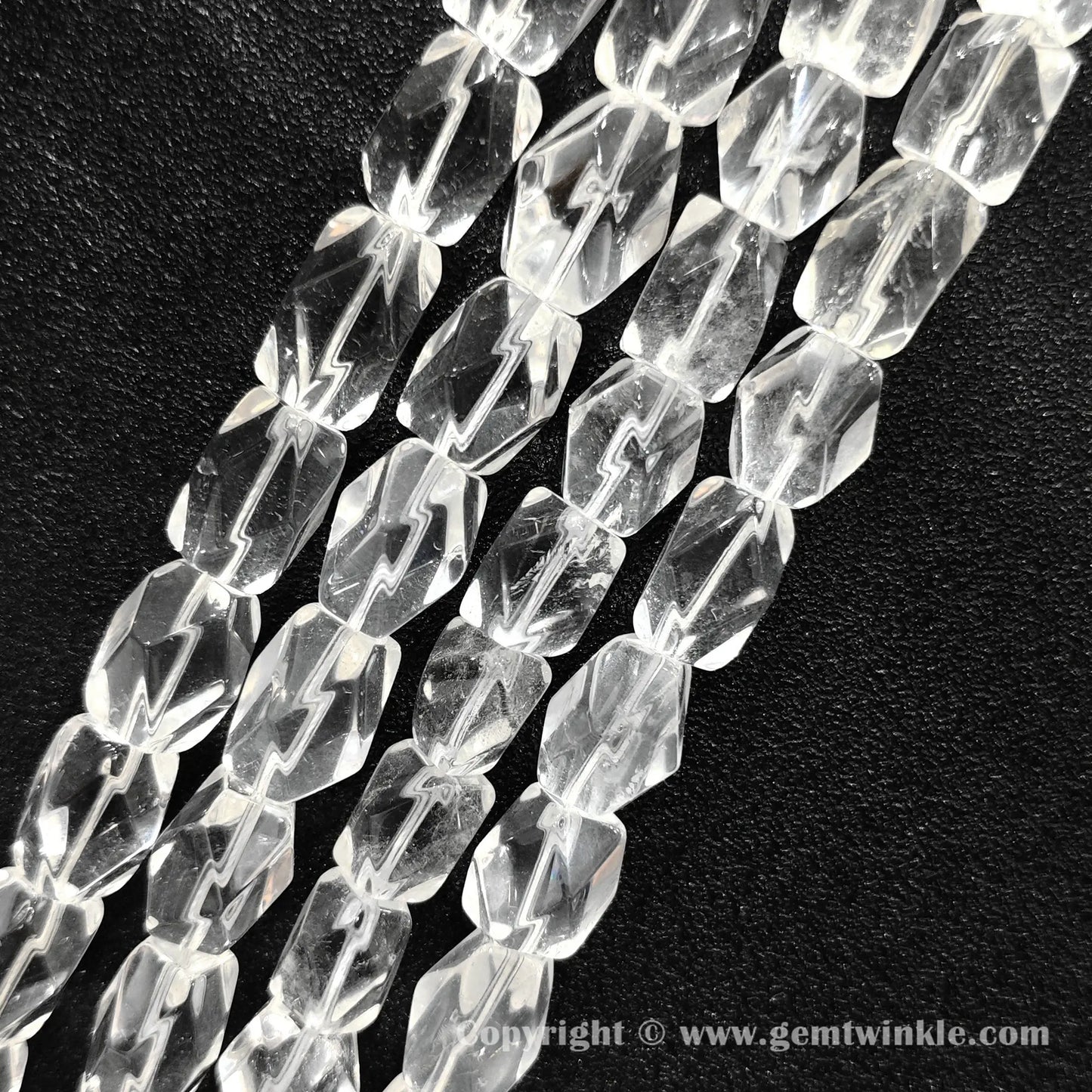 Close up view of polygonal column cut clear quartz beads with natural light reflections