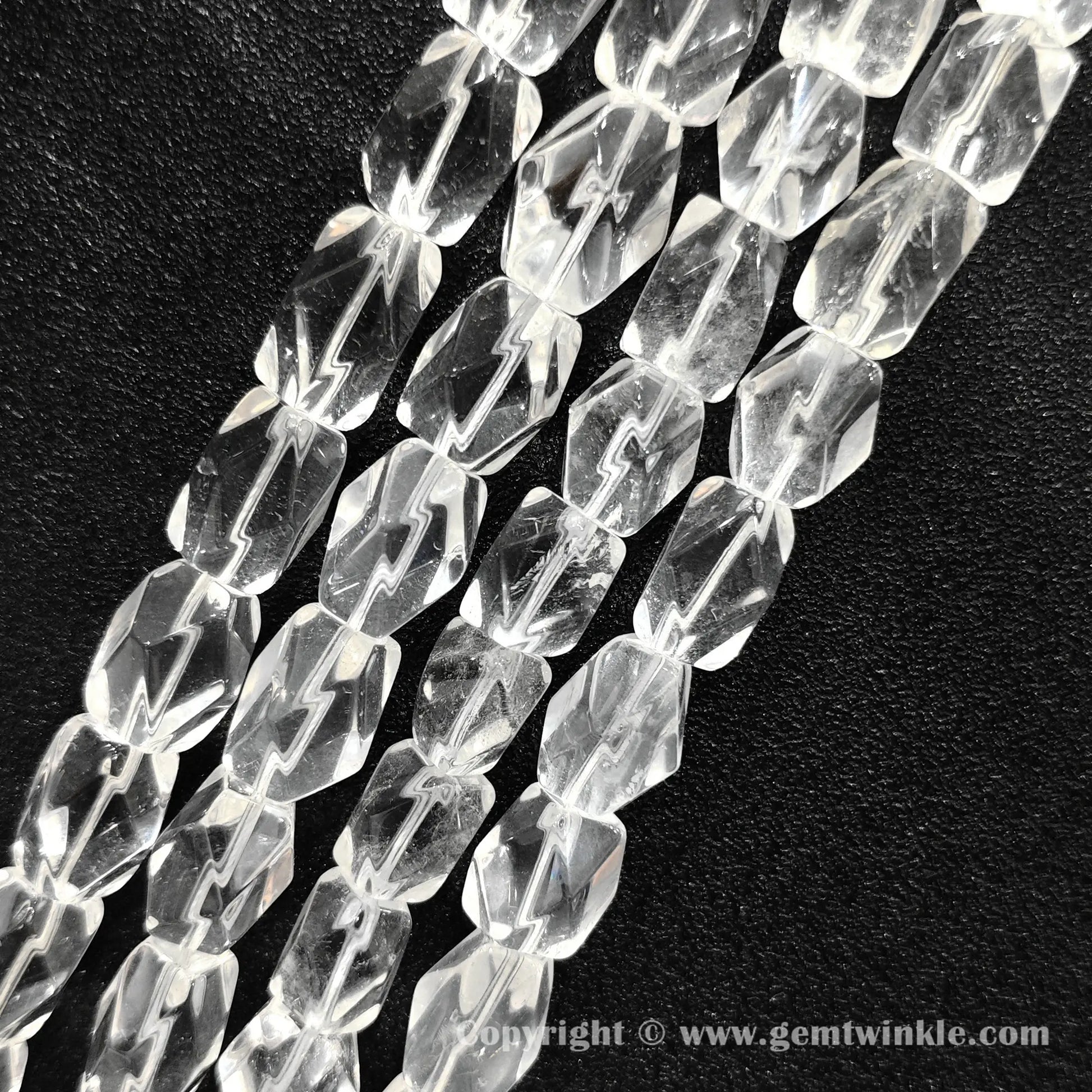 Close up view of polygonal column cut clear quartz beads with natural light reflections