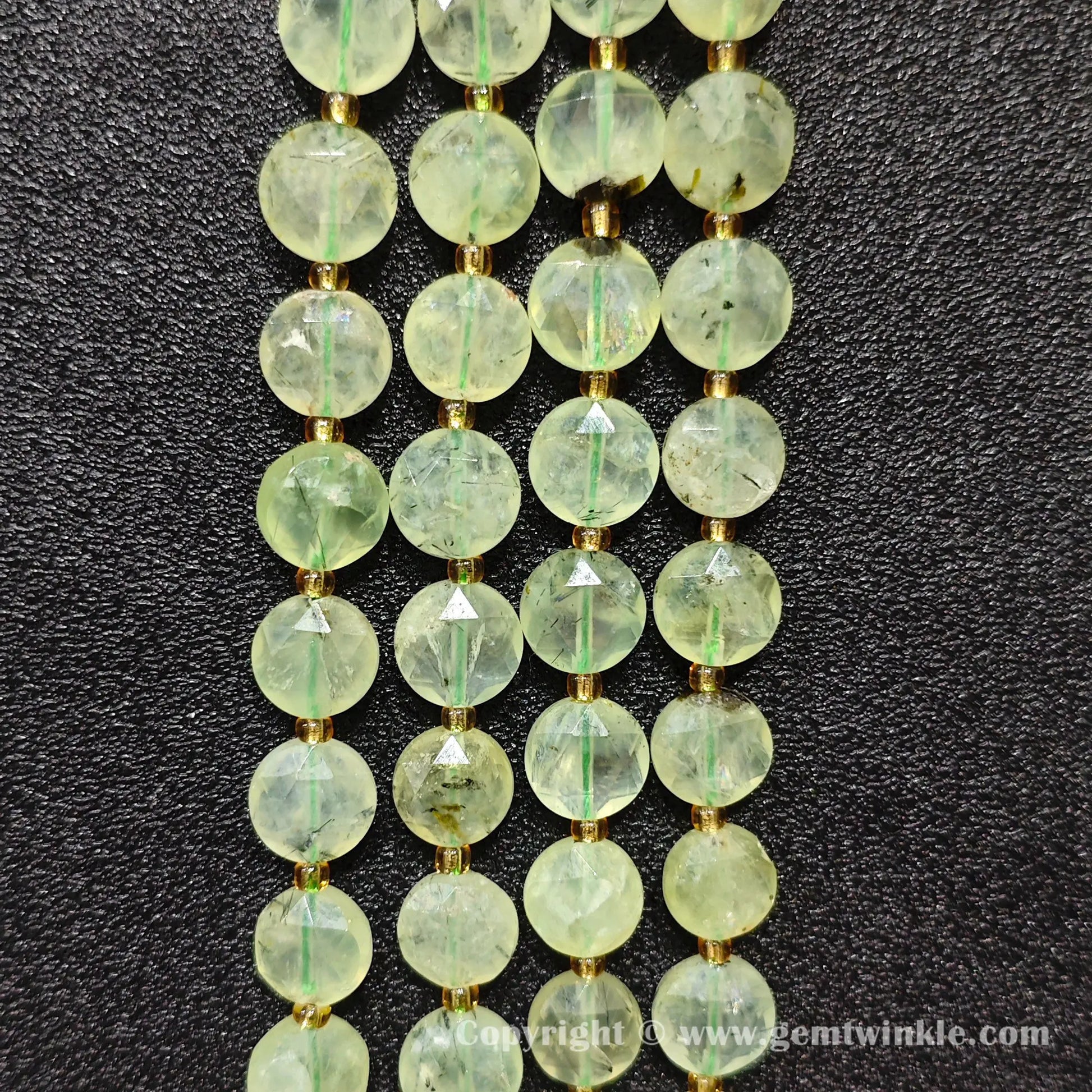 Side view of prehnite black tourmaline inclusion flat beads displaying bead thickness