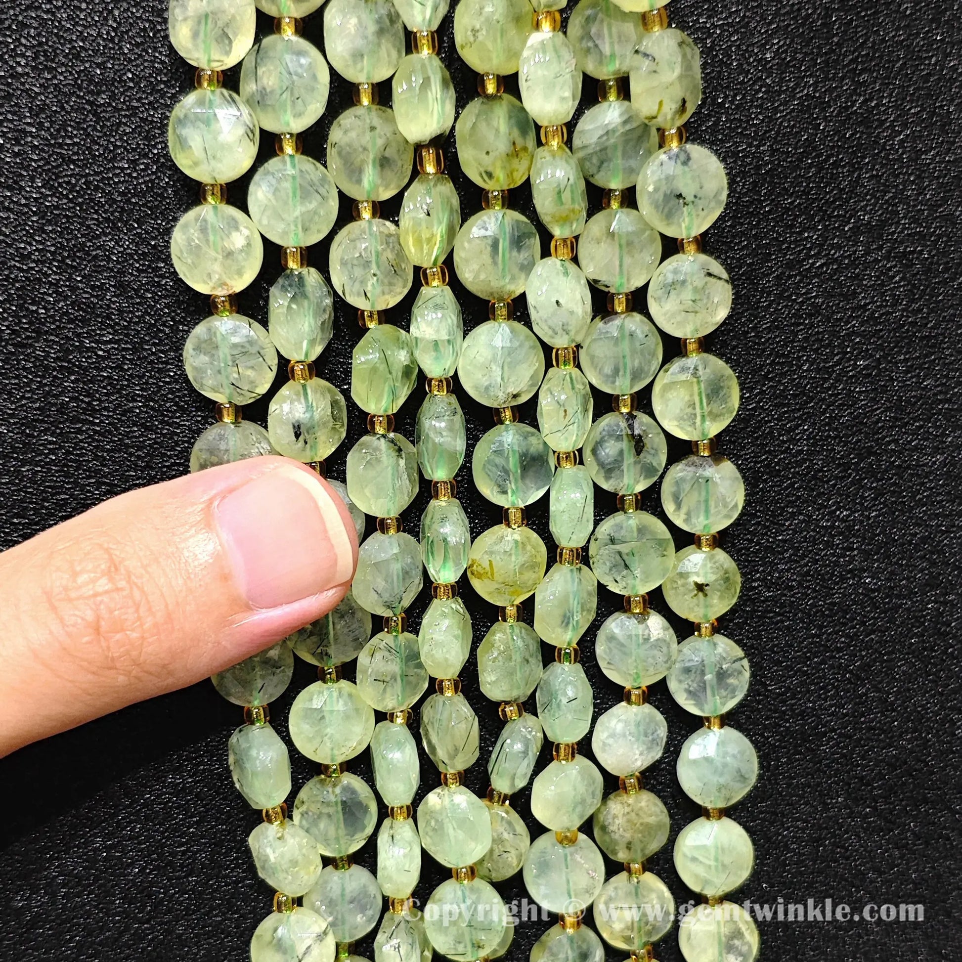 Hand holding strands of prehnite hexagram flat disc beads in 8mm and 10mm
