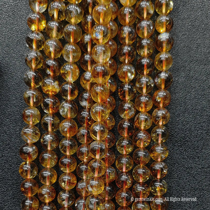 Full length vertical showcase of premium 10mm heat treated citrine bead strands indicating steady brightness and unique internal textures
