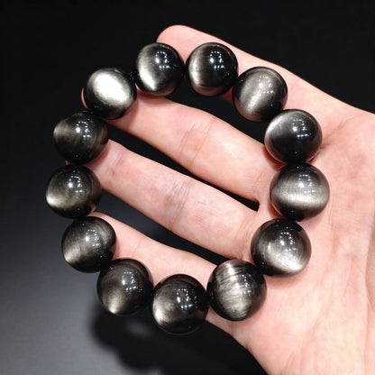 Premium select silver sheen obsidian bracelet featuring 18mm beads with sharp double eye cat eye effect