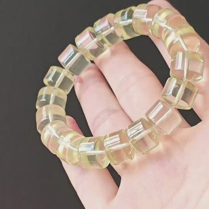 Natural lemon-yellow citrine wheel beads, ~14mm width, polished smooth, stretch elastic—displayed on hand against black background
