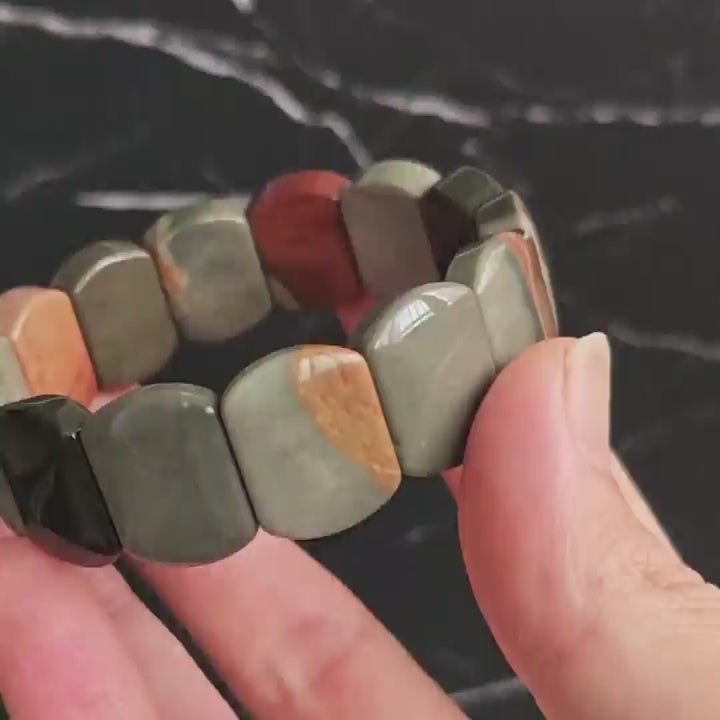 Gentle touch on ocean jasper bead—highlighting smooth finish and natural luster of the stone