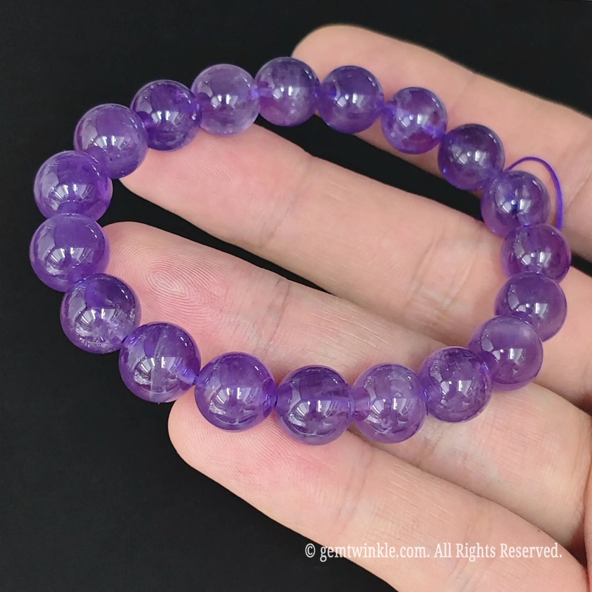 top view of purple amethyst round bead stretch bangle on hand