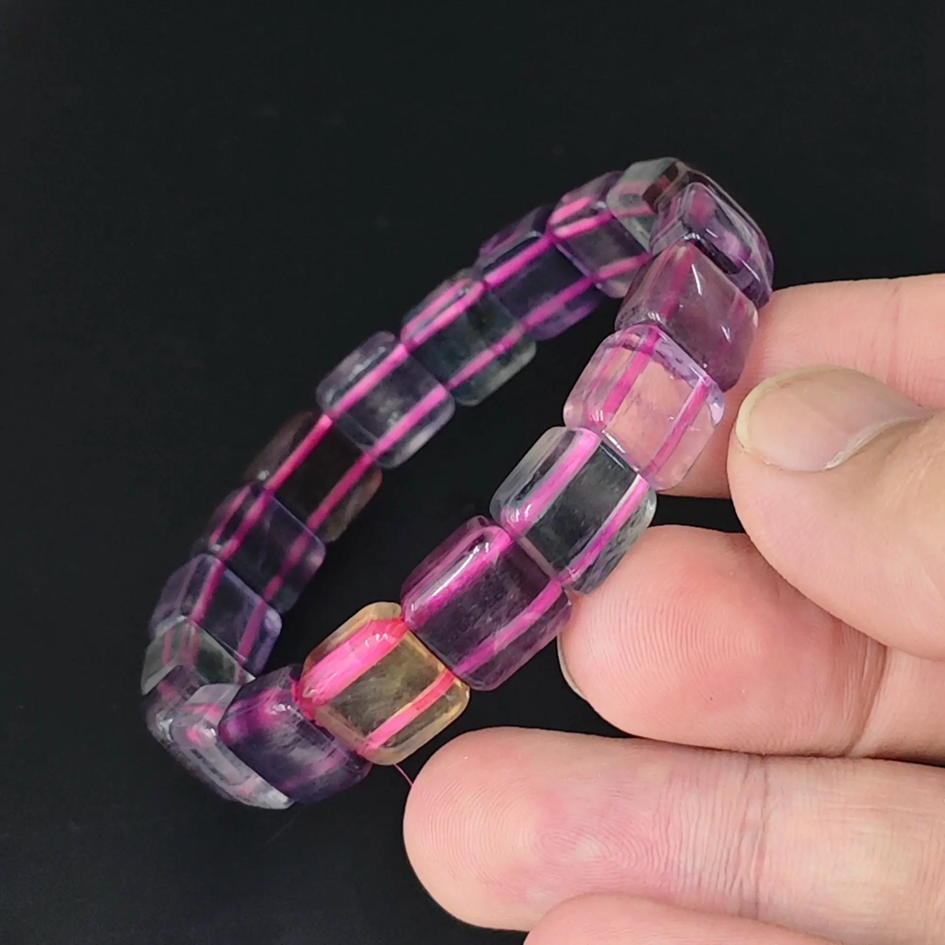 hand holding purple fluorite stretch bangle with 11mm square cube beads